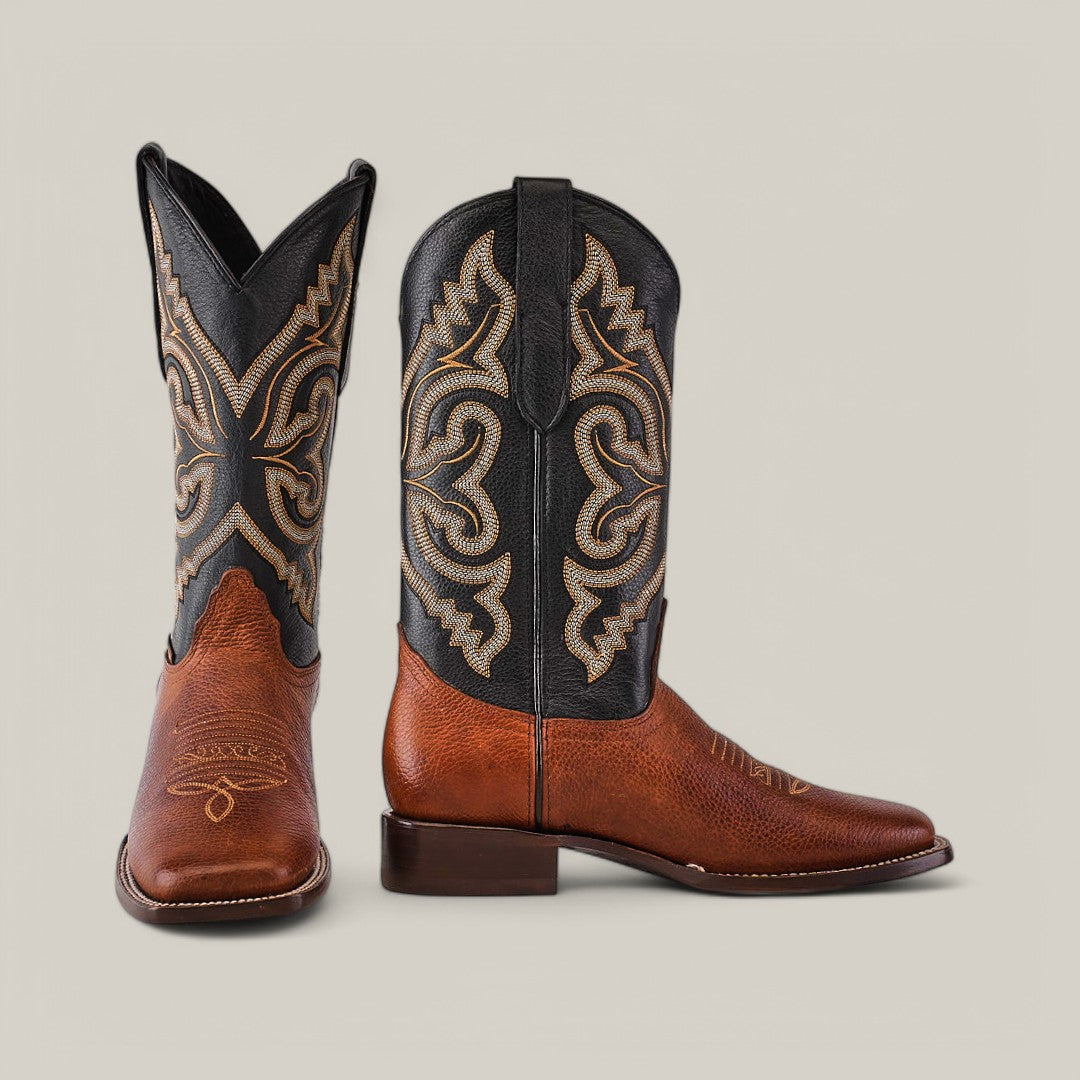 The Grisly Tan - Square Toe boots stand out in premium rich brown leather with intricate black and tan embroidery, featuring an ornate decorative design that highlights their Western-style cowboy boot appeal against a plain background.