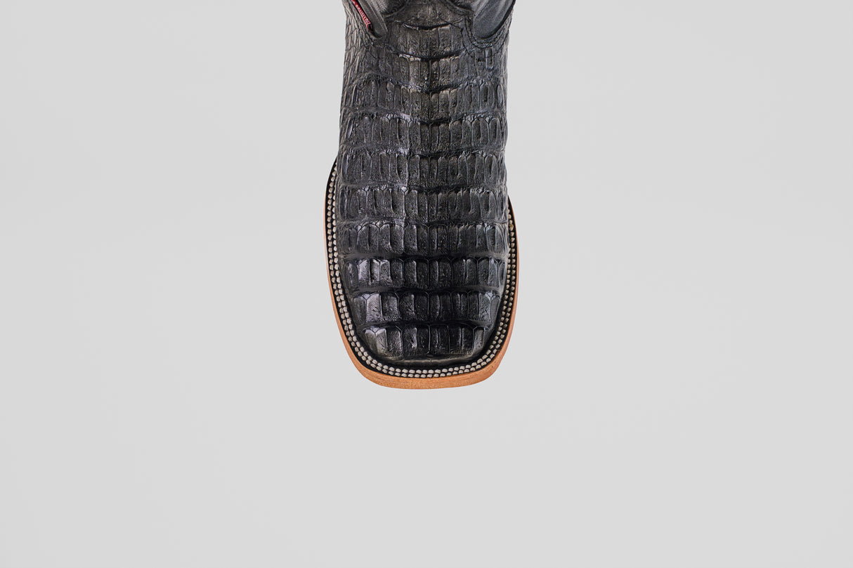 A close-up, top-down view of the Exotic Caiman Horn Back - Black - Square Toe boot highlights its textured reptile-like pattern and decorative welt stitching, showcasing the distinctive style of square toe boots.