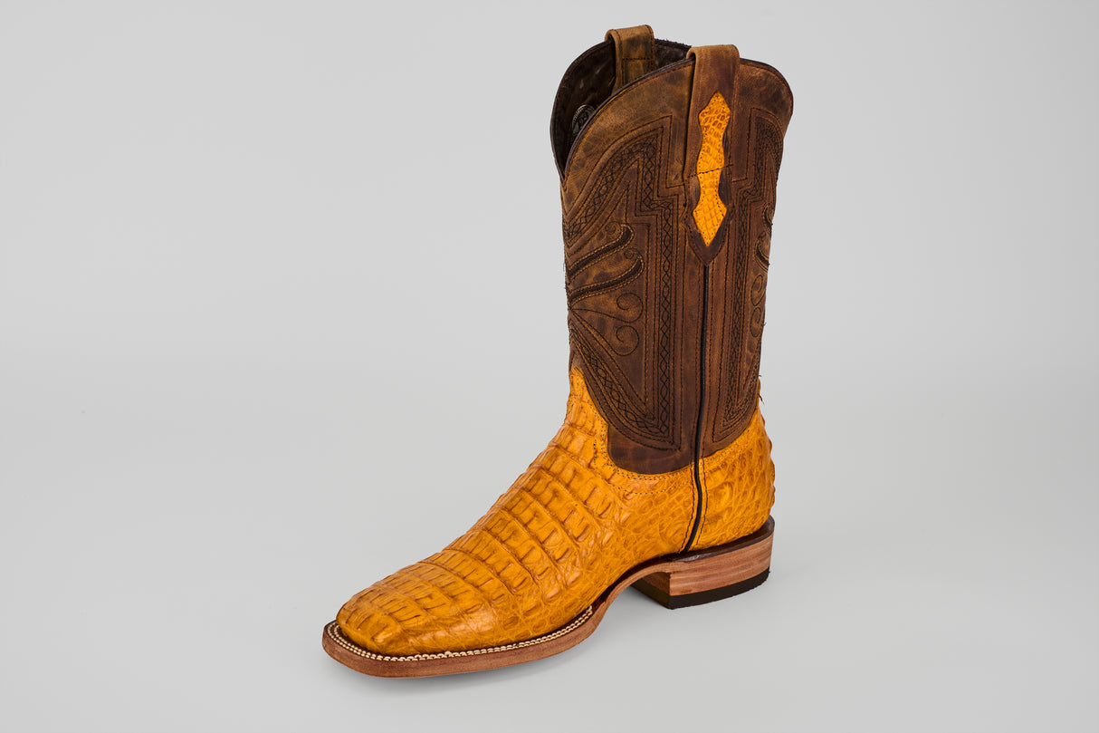 The Exotic Caiman Horn Back - Buttercup Square Toe boot features a light brown, textured lower and a darker brown, intricately stitched upper shaft, shown against a plain light gray background.