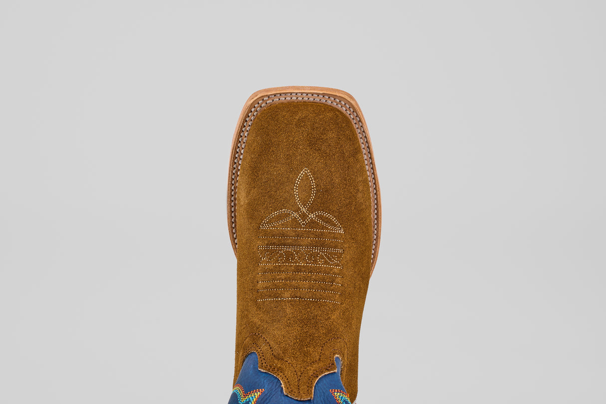 A close-up top view of the Gold Suede - Square Toe boot, crafted in brown suede with luxury white stitching on the square toe and blue ankle accents, set against a plain light background.