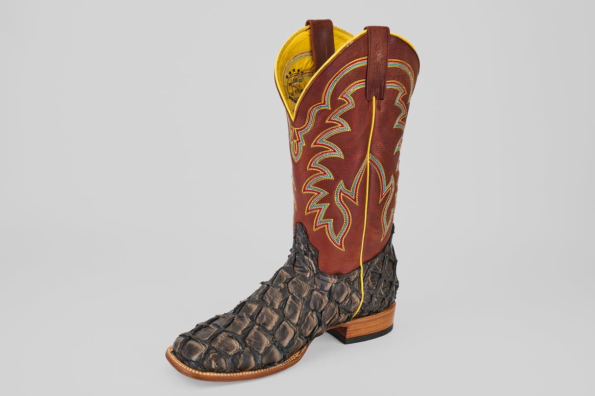 A single Butch - Caramel - Square Toe cowboy boot with a textured caramel Pirarucu leather lower, red leather upper featuring yellow and orange stitching, and a wooden heel, shown on a simple light background.