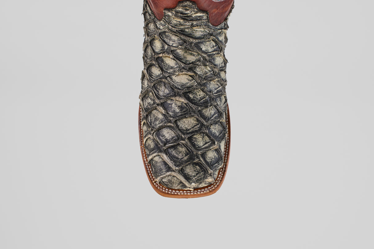 A detailed, top-down view of the Robinson - Newspaper - Square Toe boot highlights its textured Purarucu leather, brown trim, and white stitching—showcasing these distinctive handcrafted boots.