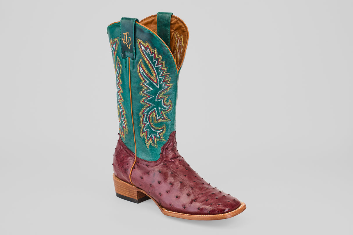 The Rusty - Wine - Square Toe cowboy boot features a textured wine ostrich leather foot, a tall teal shaft with yellow, red, and blue stitching, plus a wooden heel and tan sole.