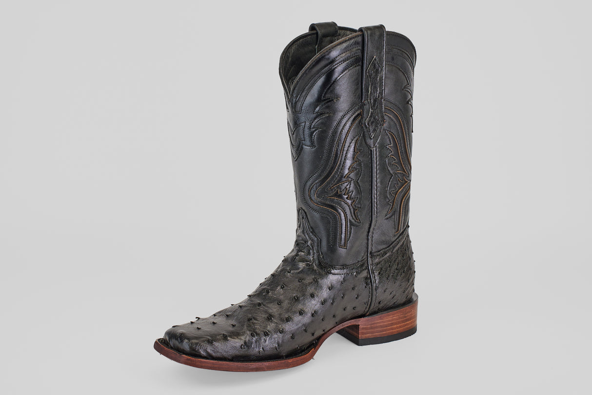 The Exotic Ostrich - Black - Rodeo Toe cowboy boot showcases black ostrich leather with quill bumps, decorative shaft stitching, and a stacked wooden heel—ideal for classic western style. Displayed on a plain light background.