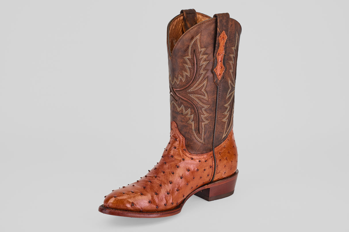 A single Exotic Full Quilt Ostrich - Brandy - Round Toe boot with a brown leather upper, decorative stitching, and a textured light brown ostrich lower, shown against a plain light gray background.