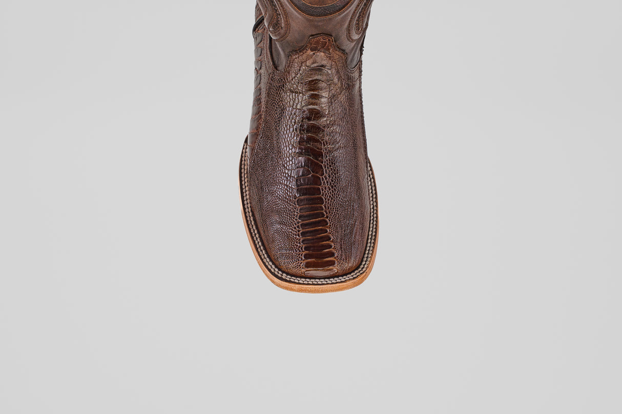 A close-up of the toe on the Austin Leg - Brown - Square Toe cowboy boot, featuring textured ostrich leather and detailed stitching, set against a plain light gray background.