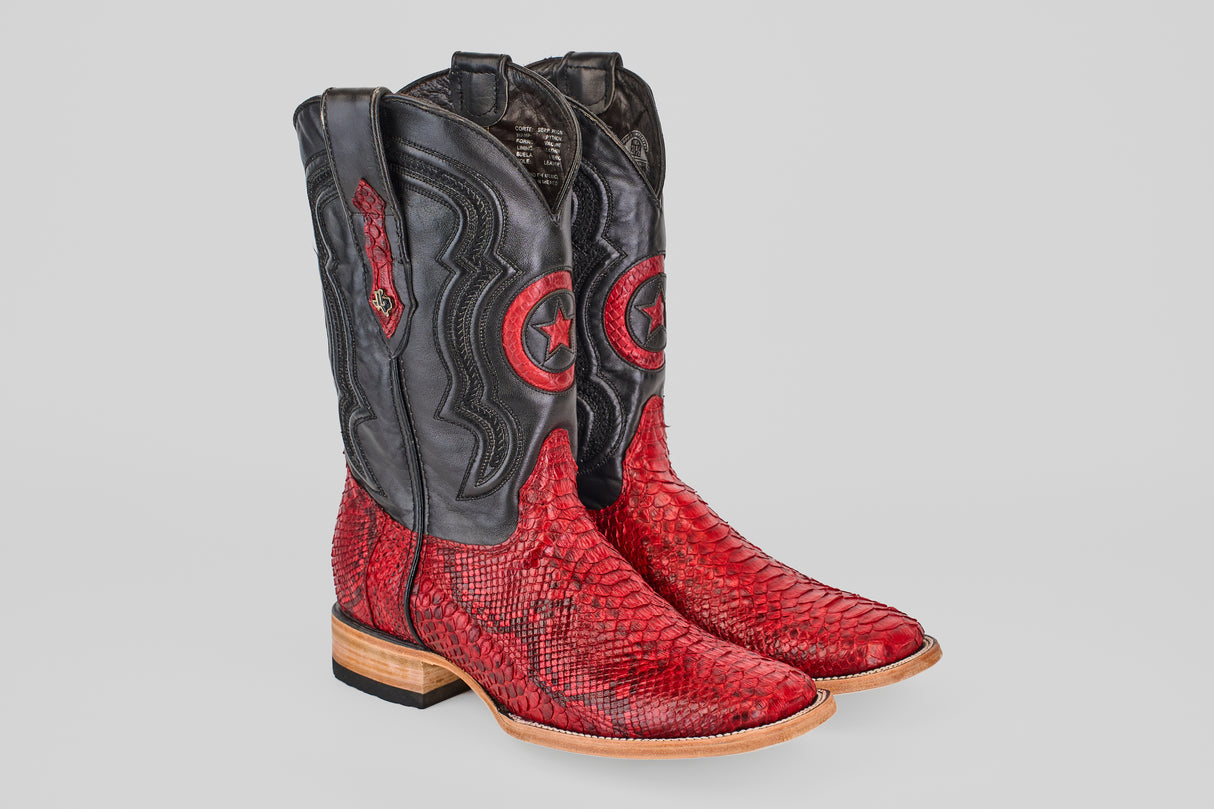 The Tanner - Ruby - Square Toe boots feature red Python Rojo snakeskin-textured lowers, black uppers with a circular star design, decorative stitching, light wooden soles, and a slight heel.