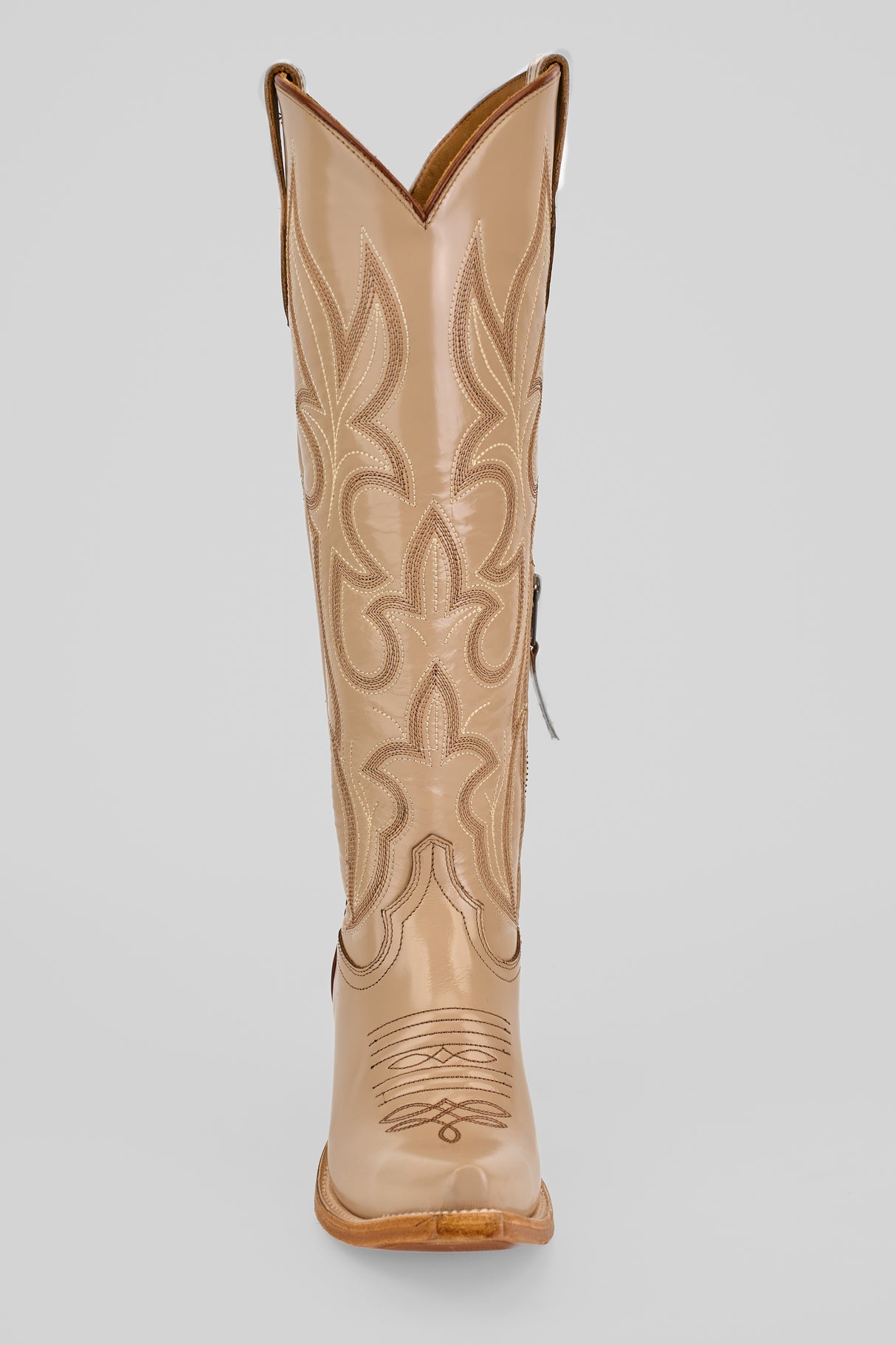 The Allison Cream - Tall Shaft - Snip Toe is a single tan boot with decorative stitching and a pointed toe, displayed upright against a light gray background. Ideal for women looking for stylish cowboy boots.