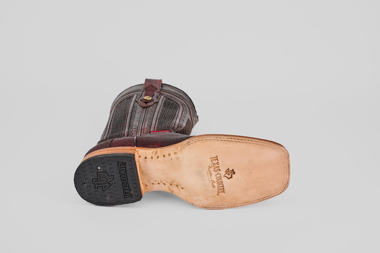 The Ranger – Wine – Square Toe boot rests on its side, revealing a leather sole with the Twisted X logo, tan stitching, a black rubber heel, and an upper of dark brown textured leather with decorative stitching in a classic square toe style.