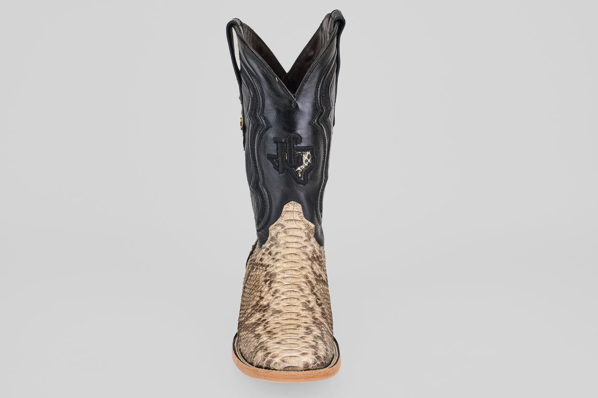 The Tanner - Matte Natural - Square Toe boot features a textured tan python leather lower, black leather upper, decorative stitching and embossing, shown from the front against a plain light gray background.