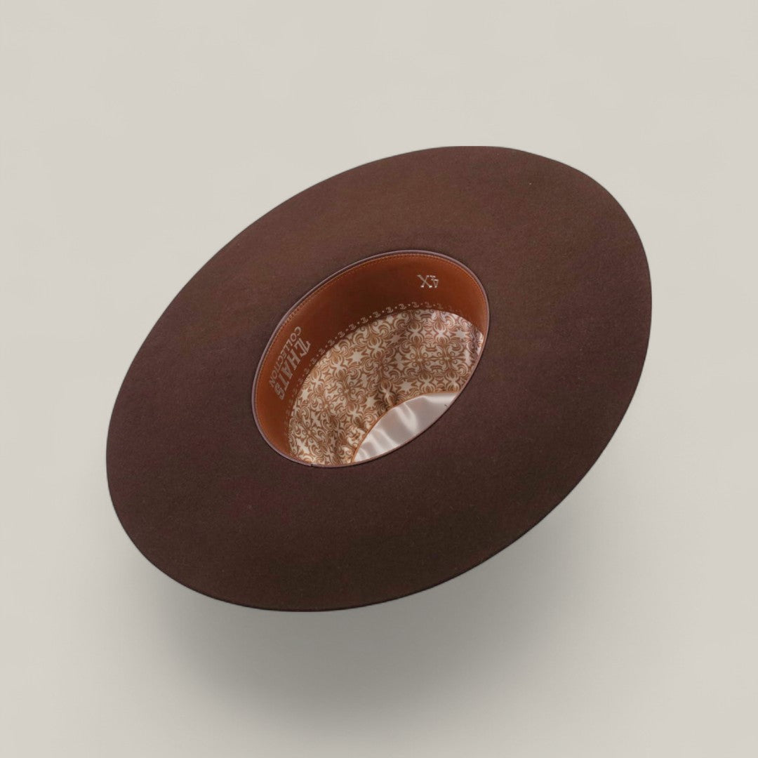 The 4X - Chocolate - TC Hats Western hat is pictured upside down, displaying its floral satin lining and leather inner band with gold lettering against a plain light background.