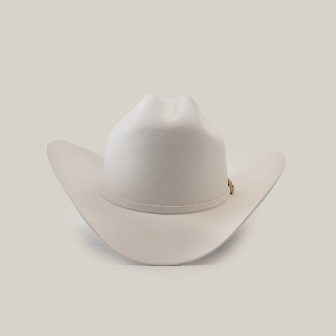 The 500X Superior White cowboy hat, made from belly beaver fur, boasts a wide brim and pinch front crown. This luxurious headwear stands out elegantly against a simple backdrop, ideal for those desiring premium Western style.