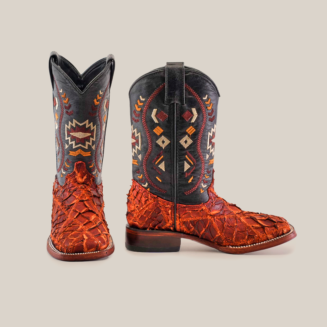 A pair of colorful cowboy boots with intricate patterns and textured leather. The left boot is facing forward, showing the front and side designs, while the right boot is turned to display the side and back.