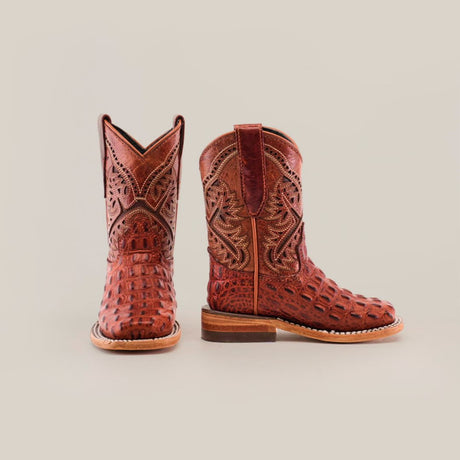 A pair of intricately designed brown cowboy boots with detailed patterns. The boots have a glossy finish and a low heel, set against a plain white background.