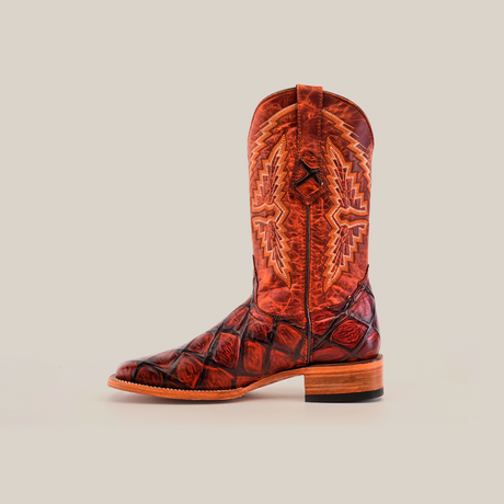 A single Big Bass Pirarucu Print Cogñac cowboy boot features a crocodile pattern, intricate shaft stitching, and wooden heel with a premium cowhide finish. The square toe design enhances its style, set against a plain white background.