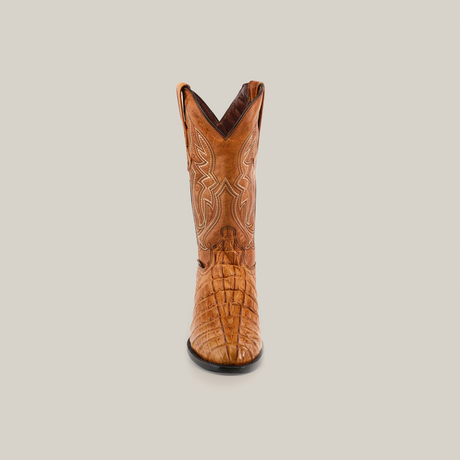 The Crocodile Tail Print Buttercup - Round Toe is a brown cowboy boot made from premium cowhide leather with intricate stitching. It features a genuine leather sole and is displayed against a white background, presenting a clear front view.