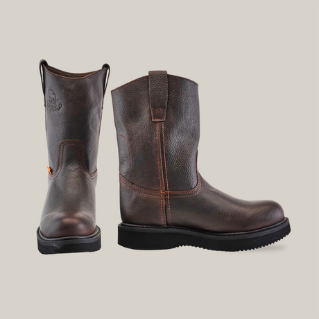 The Brown Roper - Laredo Sole - Composite Toe work boot features premium cowhide, a sturdy black sole, and side orange tag. It includes a pull-on loop, stitched accents, and an embossed brand logo near the top. The plain white background highlights its exceptional craftsmanship.