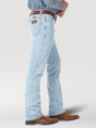 A side view shows a person in light blue Wrangler Cowboy Cut Slim Fit Jeans - 0936GBH, with a brown belt and cowboy boots, standing against a plain background. The jeans feature classic stitching on the back pocket.