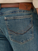 Close-up of the Wrangler Mens 20X Extreme Relaxed Fit Jeans - 1044MWXMA shows a back pocket with decorative stitching, brown leather belt at the waist, and a branded leather patch. These premium denim jeans boast a slightly faded look, offering relaxed fit and ultimate comfort.