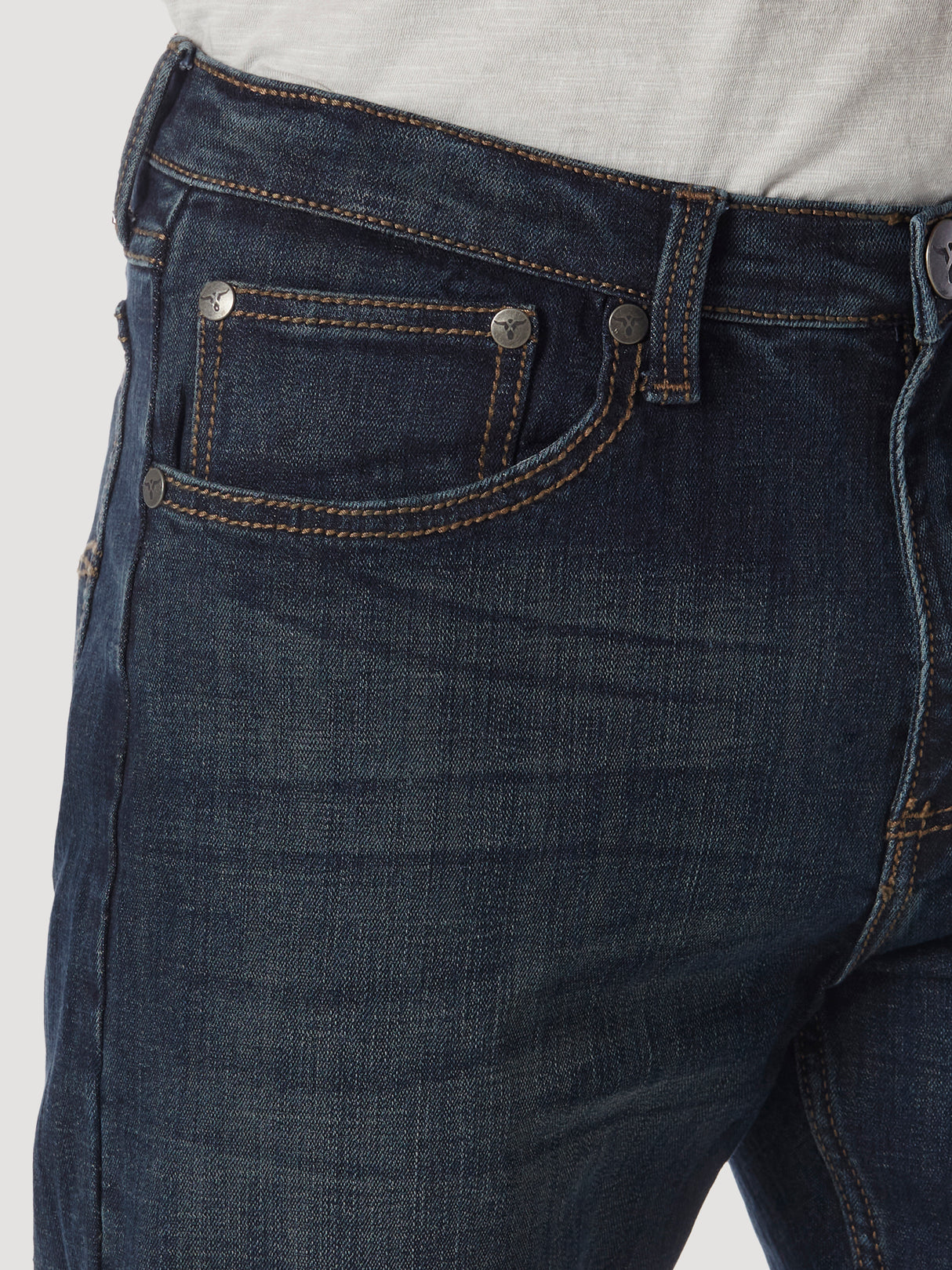 Close-up of a person wearing Wrangler 20X No. 33 Extreme Appleby Dark Wash Relaxed Straight Leg Jean, featuring visible stitching and metal rivets. The premium denim with a classic five-pocket design pairs perfectly with a light grey top.