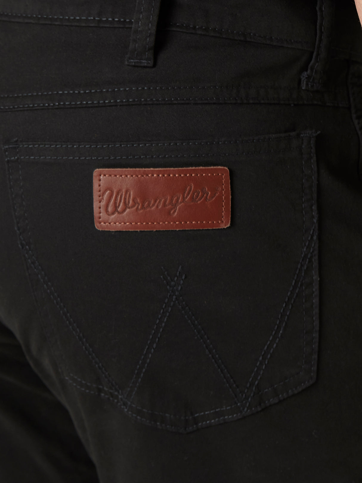 Close-up of Mens Wrangler Retro Slim Fit Straight Leg Pant - 88MWZBK in black, highlighting the back pocket with dark stitching and a brown leather patch embossed with Wrangler, showcasing their premium denim craftsmanship.