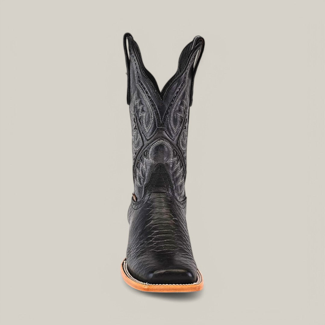 The Python Print Black - Square Toe cowboy boot showcases detailed stitching and patterns on its shaft, with an understated python print. Its leather upper and tan sole are photographed from the front against a solid light gray background.