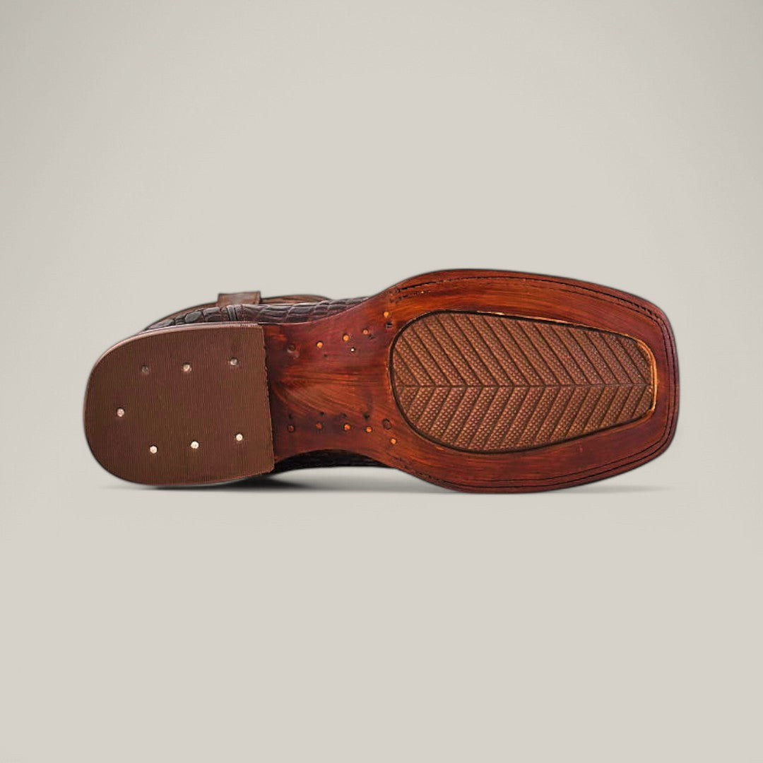 The image features the underside of the Alligatoar Horn Back Print Brown - Square Toe dress shoe, highlighting its wooden sole with a textured rubber heel and visible threads and studs. The shoe is elegantly captured against a plain off-white background.