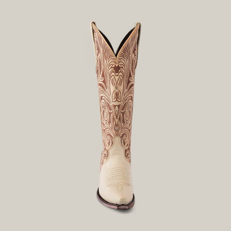 The Cavalier Laser Cream boot, featuring a tall shaft and snip toe, boasts intricate brown embroidery against a plain light background.