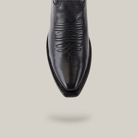 Top view of the Miranda Clayton Black Leather Sole Mid Shaft boot, featuring a snip toe with intricate stitching. Set on a plain beige background, the pointed toe and decorative embroidery lend sophistication to these black leather boots.