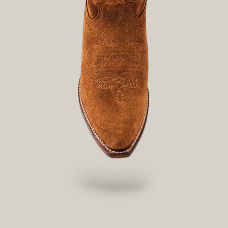 The Miranda Suede Caramel Leather Sole boot features luxury craftsmanship with decorative stitching and a snip toe, highlighted in a top view against a light gray background.