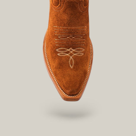 A close-up of the Kellie Suede Almond Lether Sole boots showcases their premium leather sole and decorative stitching, with intricate patterns and a snip toe design elegantly set against a neutral background.