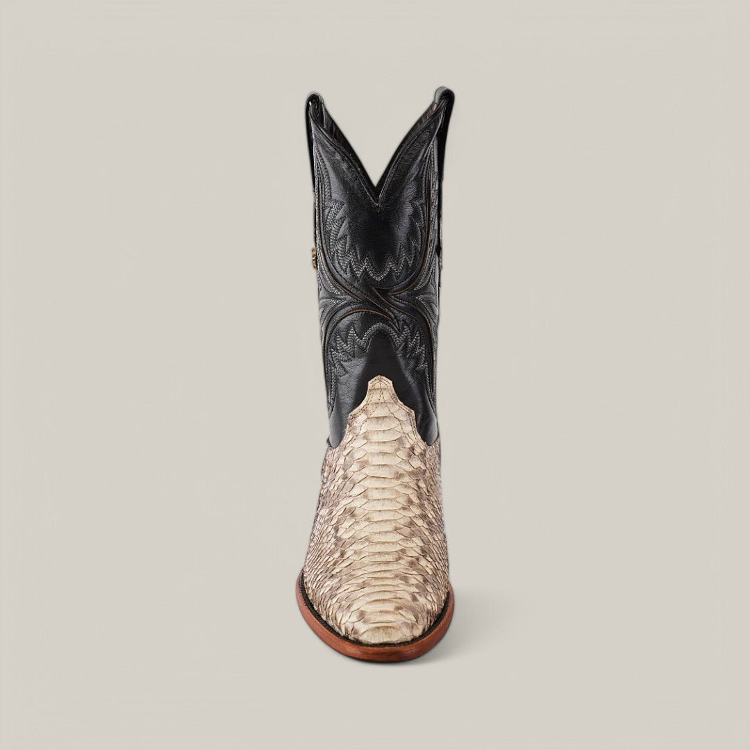 The Exotic Python - Natural - Round Toe cowboy boot features a textured light tan foot made from luxurious natural python leather with a black upper and decorative stitching, set against a plain beige background.