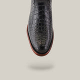 Close-up of the Exotic American Alligator Belly - Black - Roper Toe shoe on a light gray background, showcasing its rounded toe and brown sole.