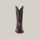 A single cowboy boot crafted from Exotic American Alligator Belly leather stands out with intricate stitching in a mix of dark brown and burgundy hues. It features a square toe and curved pull tabs, displayed elegantly against a plain light gray background.