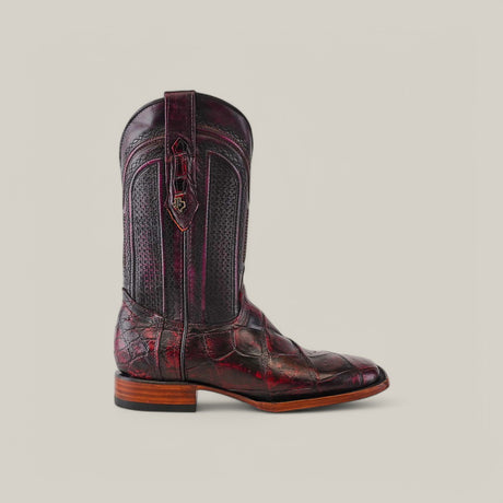 A single intricately designed Exotic American Alligator Belly boot in black cherry with textured black inlays and a wooden heel sits against a plain background. With classic stitching, a square toe, and a pull-on loop, this boot showcases distinctive style.