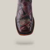 A close-up of the Exotic American Alligator Belly boot in black cherry, highlighting its square toe and unique patchwork design in dark brown and burgundy, complemented by a light brown sole.