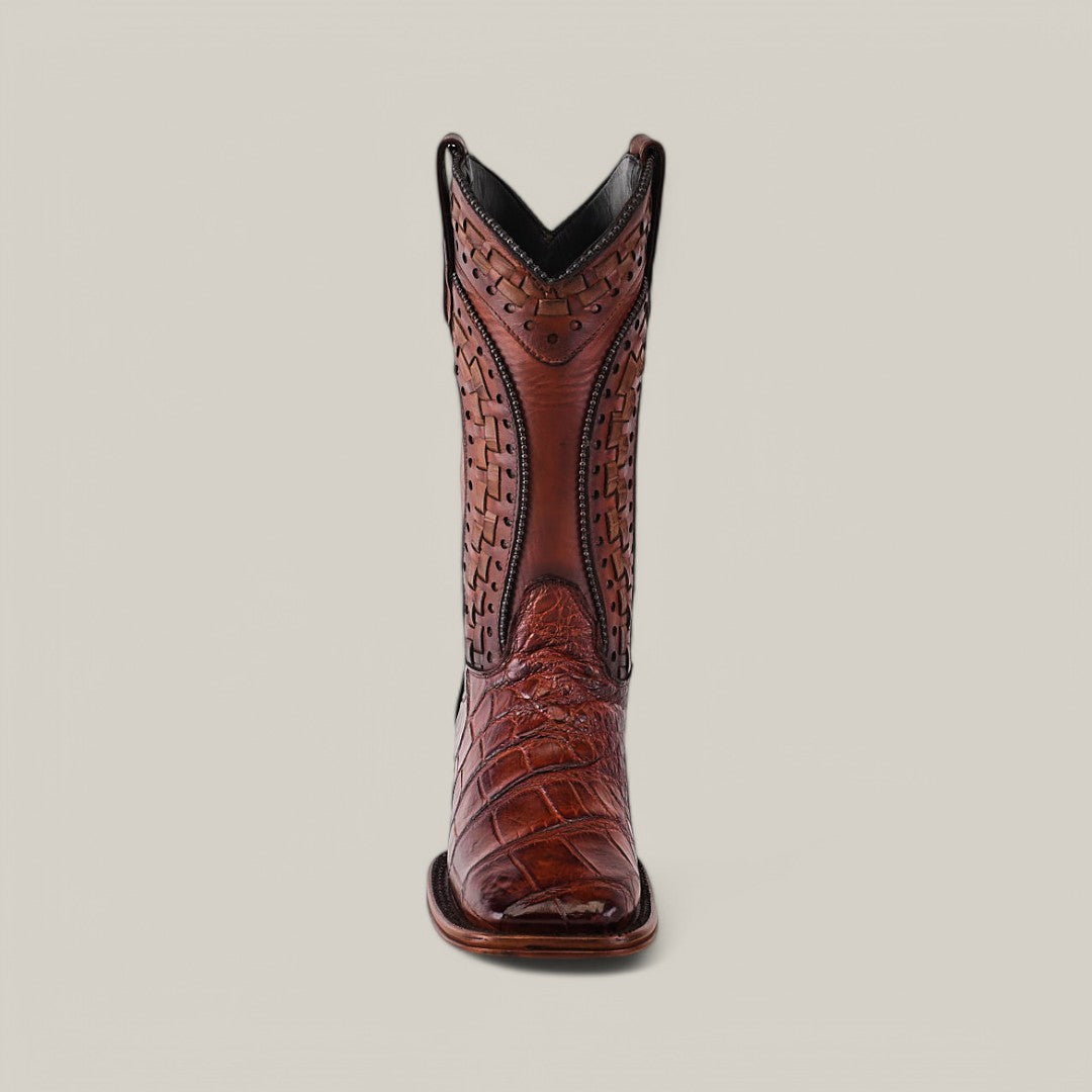 One Exotic American Alligator - Herradura boot in Brandy color stands upright, highlighting intricate stitching on authentic alligator leather. With detailed patterns and a square toe, the boot is set against an off-white background to emphasize its craftsmanship.