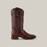 An Exotic American Alligator - Herradura Taupe Square Toe boot captures attention with its intricate stitching and designs. It features a textured, reptile-like pattern on the lower half, decorative tooling on the shaft, and is set against a plain light gray background.