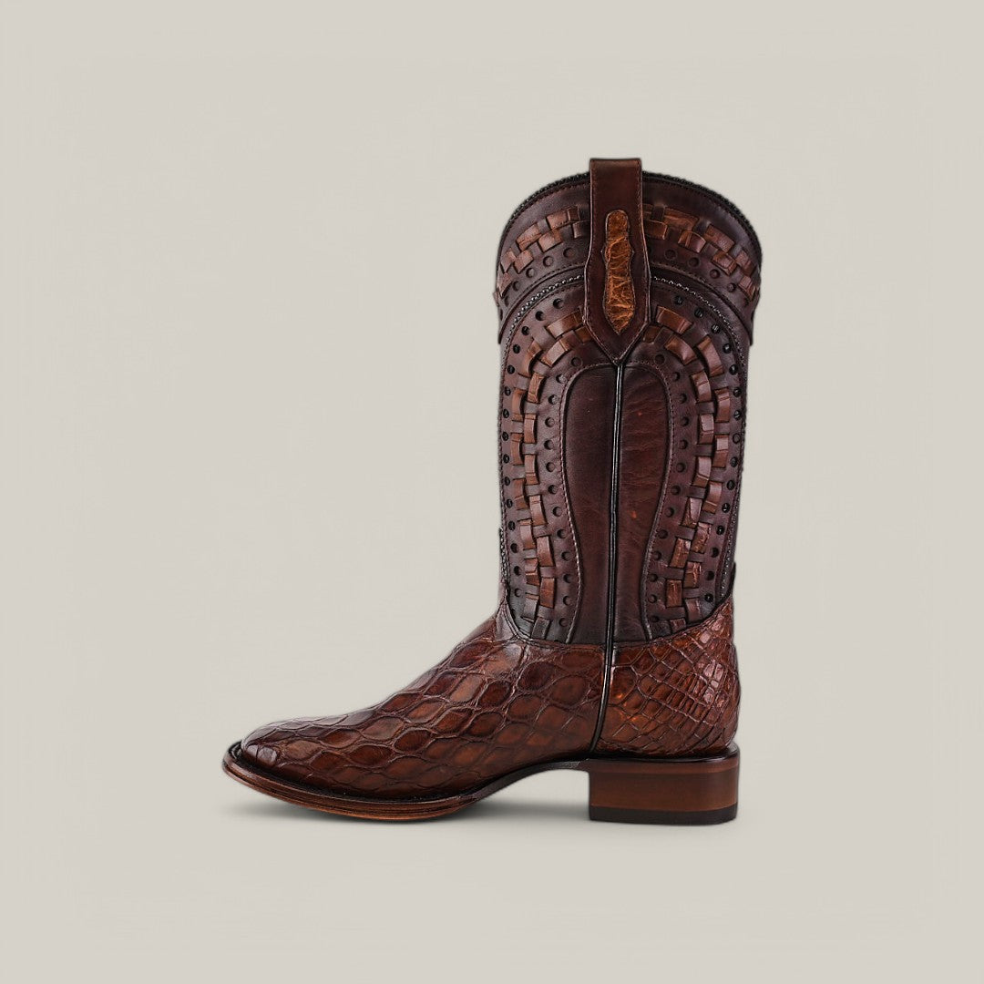 The Exotic American Alligator - Herradura boot in taupe features intricate shaft designs and a textured leather foot, complete with square toe detailing and pull straps. It has a squared-off heel, set against a plain light background.