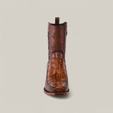 A single handcrafted Exotic American Alligator Tail boot in fawn, featuring intricate alligator leather pattern and adorned with logos and signatures on the shaft, stands upright against a plain, light gray background. This Narrow Square Toe boot exudes rustic elegance.