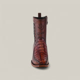 A premium single brown cowboy boot crafted from textured caiman leather features a narrow square toe and stitched detailing. The Texas-shaped logo and signature adorn the side. This Exotic Caiman - Brandy is showcased on a plain, light background.