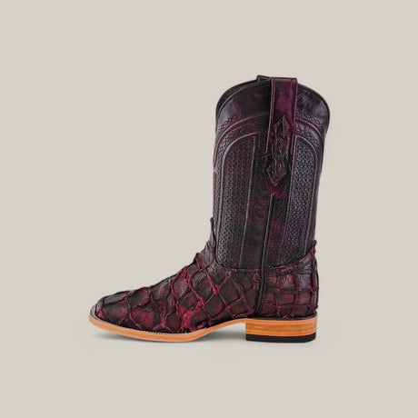 A side view of a square-toe Exotic Pirarucu Fish boot in matte black cherry with an intricate texture and elaborate shaft patterns, set against a plain light gray background.