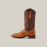 The Exotic American Alligator Hornback in Fawn features a light tan crocodile pattern on the foot with a dark brown shaft, intricate stitching, square toe, low heel, and pull tab—an elegant two-toned cowboy boot displaying sophisticated craftsmanship against a neutral background.