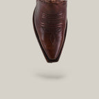 A close-up of the pointed toe on the Rachael Copper - Tall Shaft - Snip Toe boots showcases decorative stitching against a light background with a soft shadow. The perfect womens boots for standout Western style.