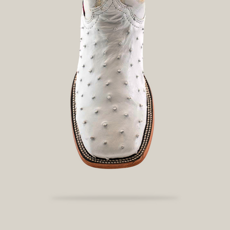 A close-up of the Exotic Full Quilt Ostrich boot in white, featuring a square toe and detailed edge stitching, set against a neutral background.