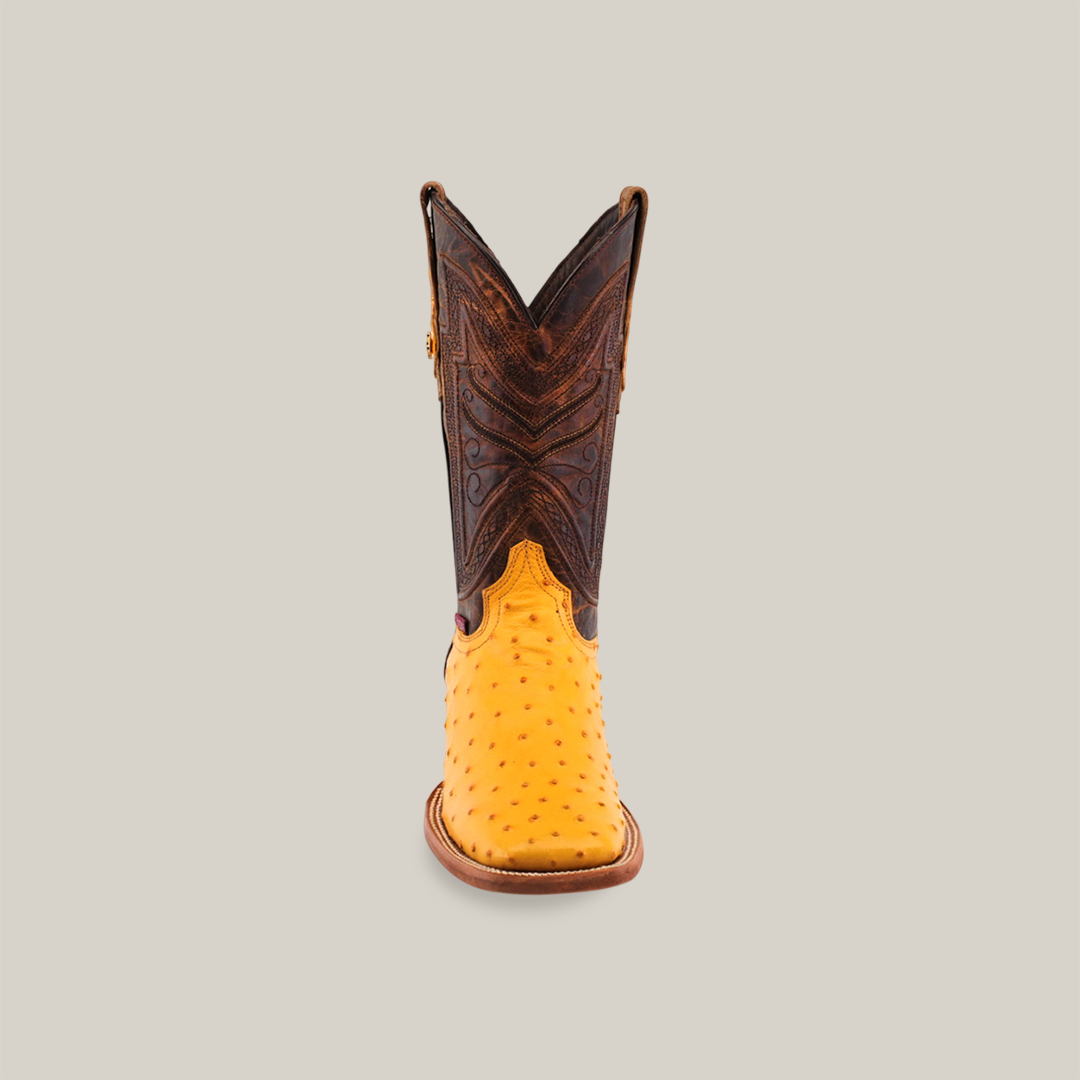 Front view of a single Exotic Full Quilt Ostrich - Buttercup- Square Toe cowboy boot in buttercup ostrich leather with a dark brown, intricately stitched shaft, set against a plain light grey background.