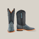 These Exotic Full Quilt Ostrich boots in Blue Jean, with intricate stitching and wooden soles, are a stunning addition to any Western wardrobe. Displayed on a light gray background, one boot faces forward for a full view while the other reveals an elegant side profile.