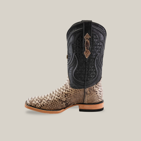 The Exotic Python - Natural - Square Toe boot showcases Western fashion with a stylish square toe, snakeskin-patterned lower section, black textured upper, intricate stitching, and a low wooden heel.