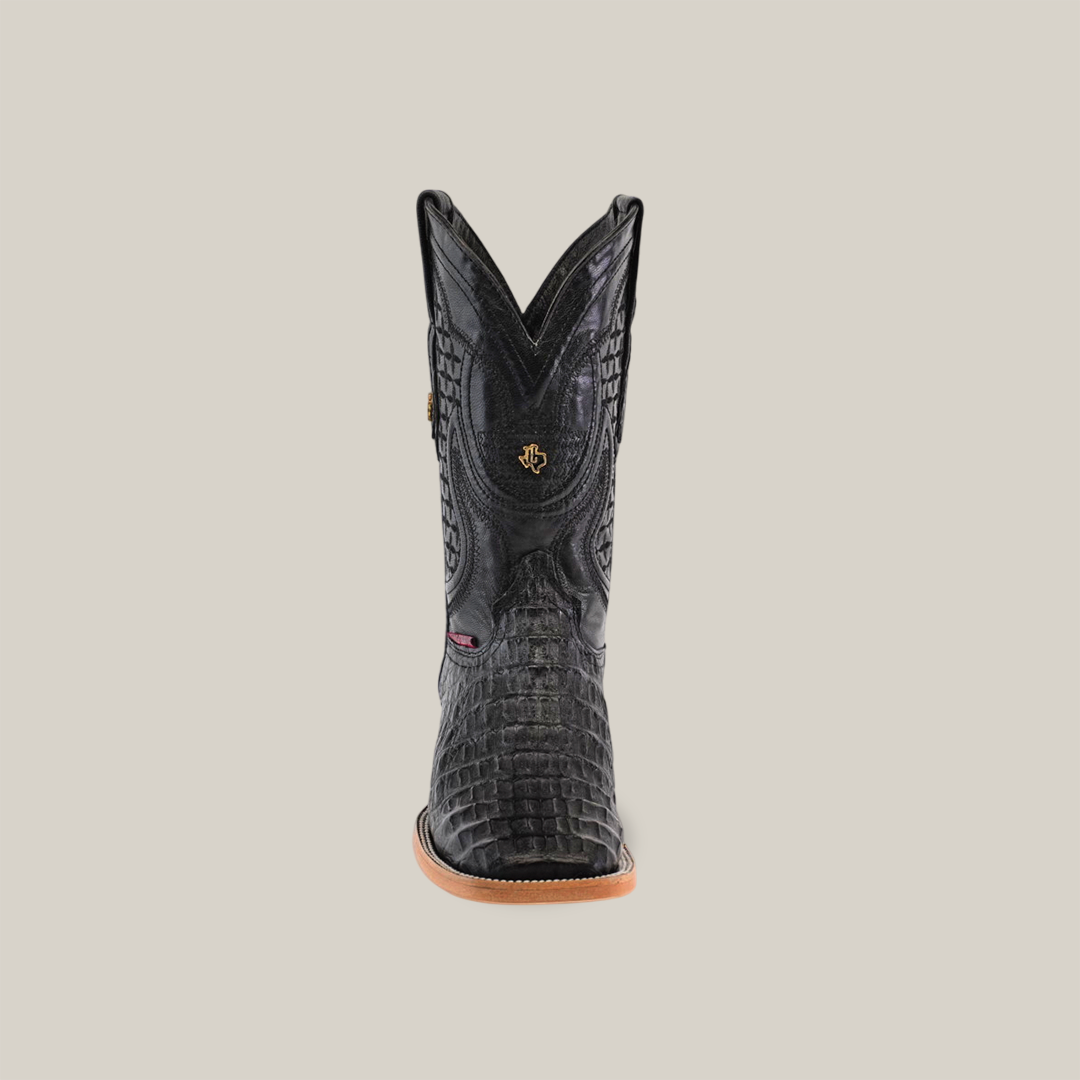 Front view of the Exotic Caiman Horn Back - Black - Square Toe cowboy boot with a textured pattern and light brown sole on a plain background. The handcrafted shaft features intricate stitching and a small emblem, highlighting its elegance.