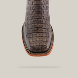 The Exotic Caiman Horn Back - Serpentine boots, gray and textured with authentic caiman leather, feature a square toe and intricate stitching detail. They are displayed from above against a plain background.